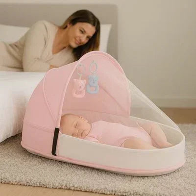Lit bebe de voyage rose avec maman à coté et la moustiquaire mise