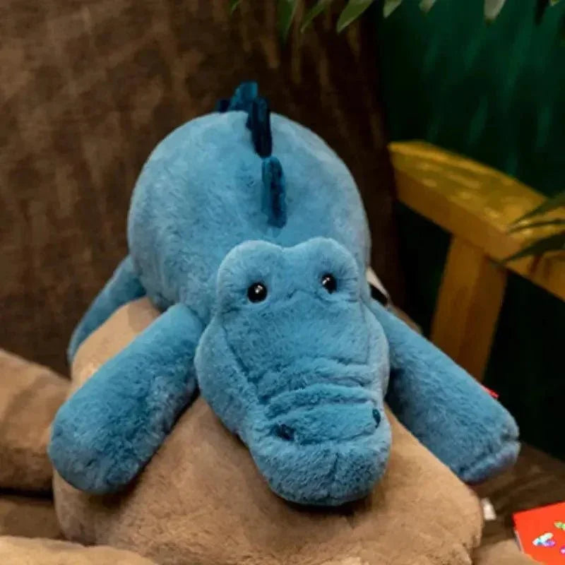 Peluche crocodile bleu pour bébé, doudou doux posé sur un fauteuil, jouet rassurant