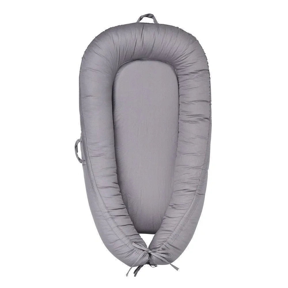 réducteur de lit bébé gris, cocon sécurisant pour nouveau-né, vu de dessus