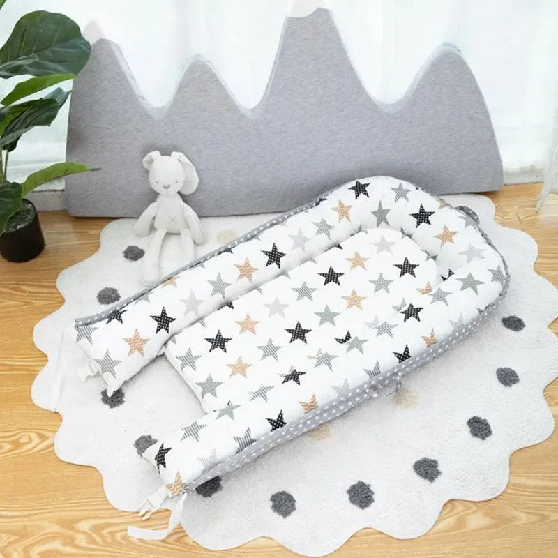 Réducteur de lit bébé étoilé sur tapis rond avec peluche et coussin montagne, décor doux