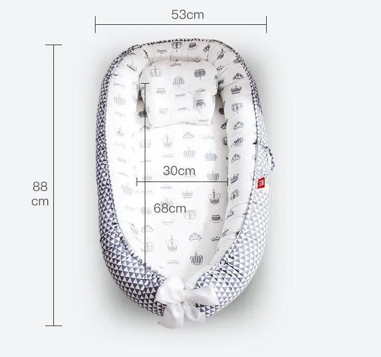 Réducteur de lit bébé blanc motifs couronnes, dimensions 88x53 cm, coussin inclus.