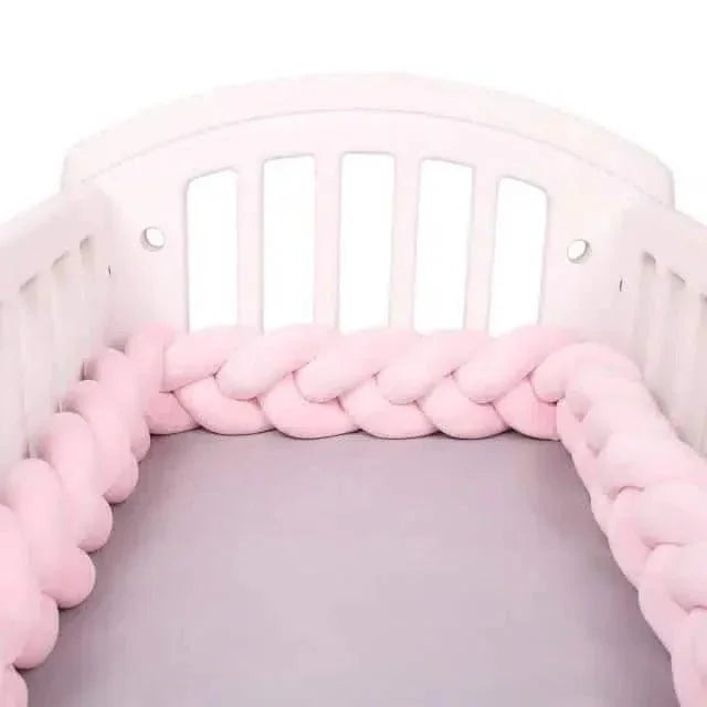 Tour de lit tressé rose installé dans un lit bébé blanc, protection sécurisée