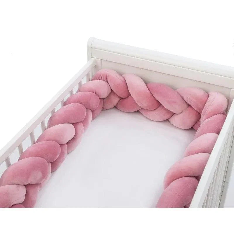 Tresse de lit rose pour bébé installée dans un lit blanc, tour de lit doux et sécurisant.