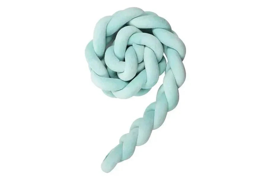 Tresse de lit vert d’eau pour bébé, douceur sécurisante, posée sur fond blanc