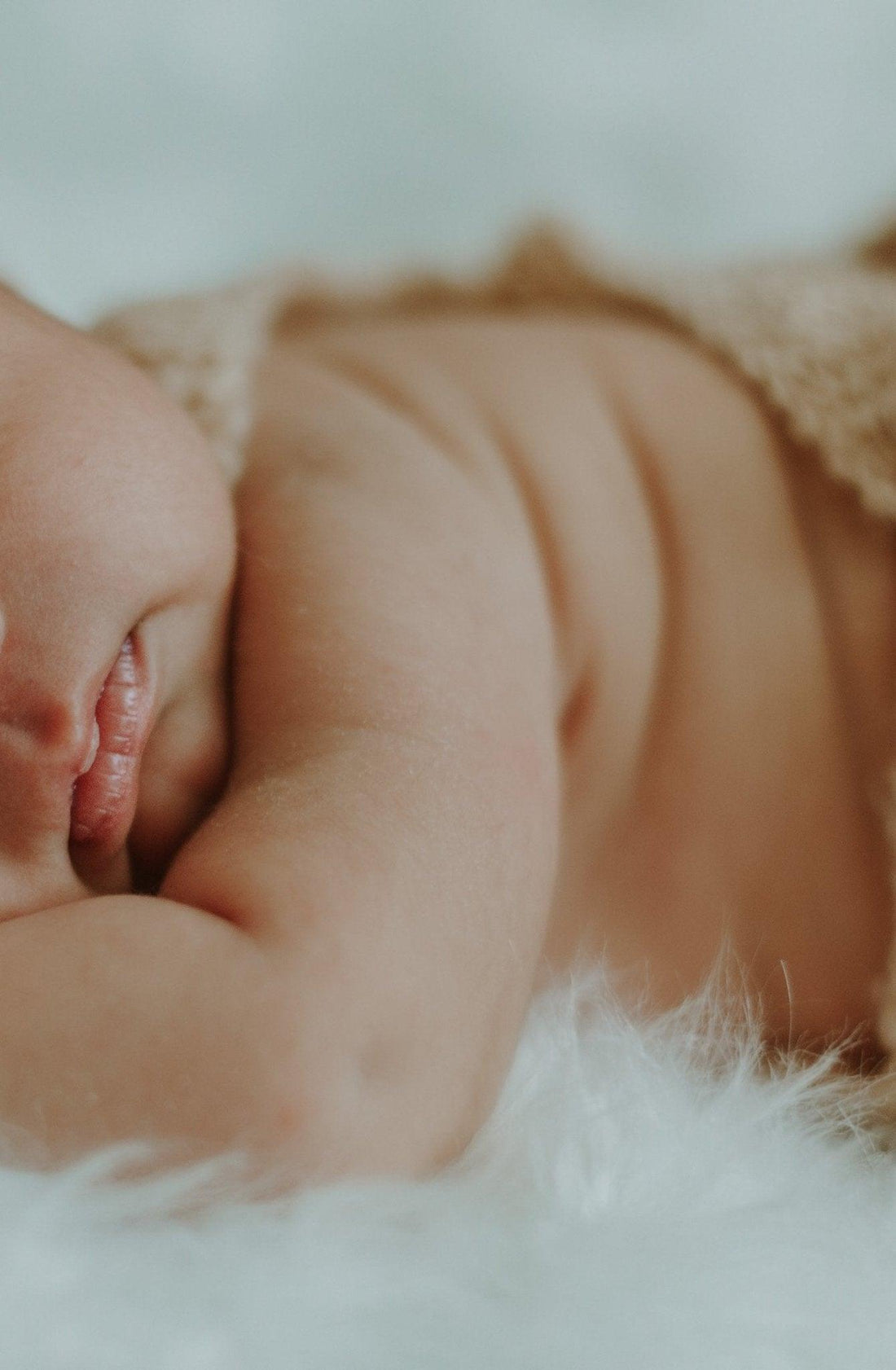 Bébé endormi sur couverture douce, lèvres détendues, ambiance rassurante