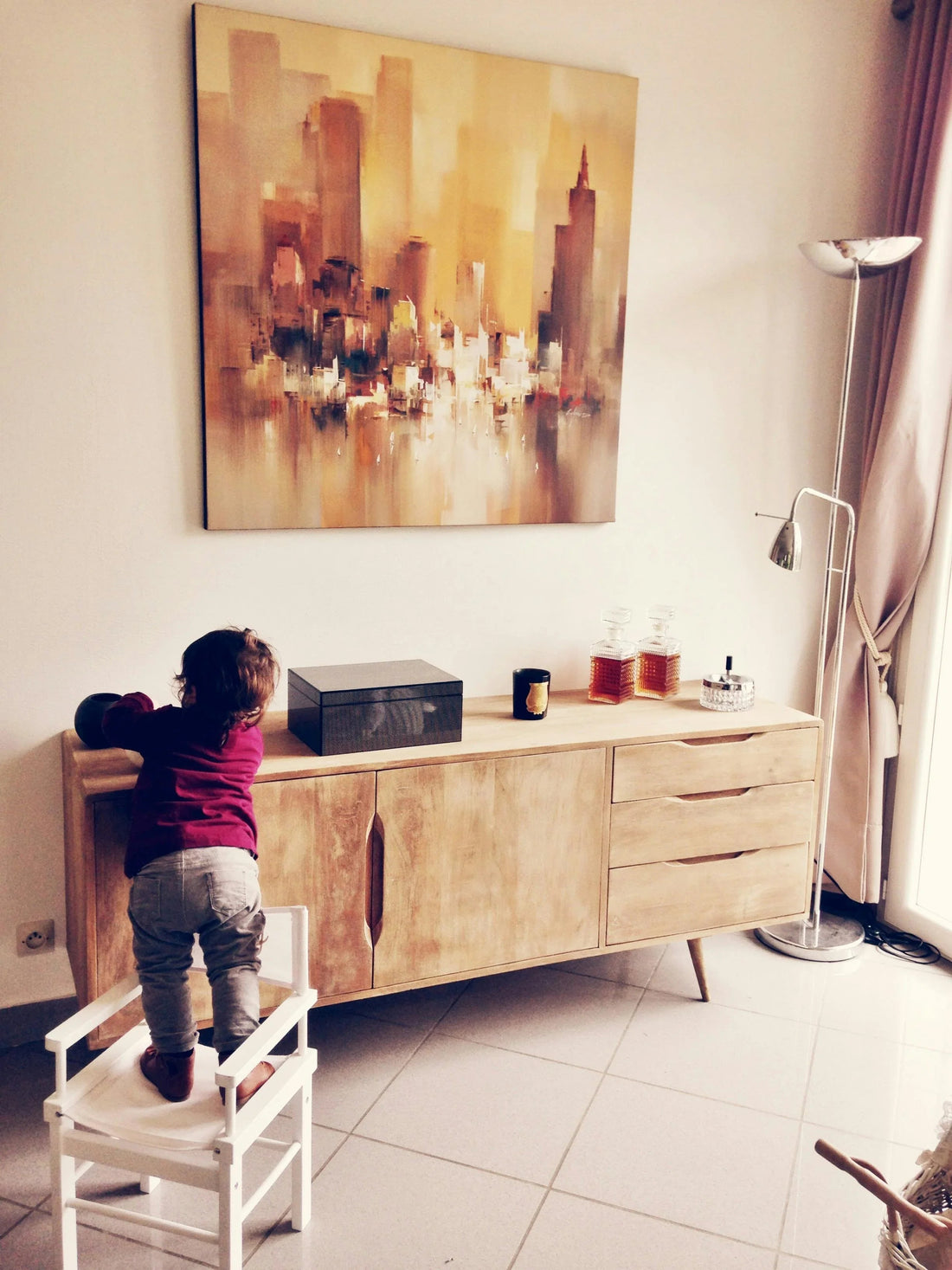 Bébé debout sur une chaise devant un buffet en bois, surveillance sécurité enfant