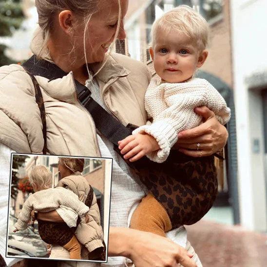 Maman portant un bébé blond en porte-bébé moderne motif léopard en extérieur