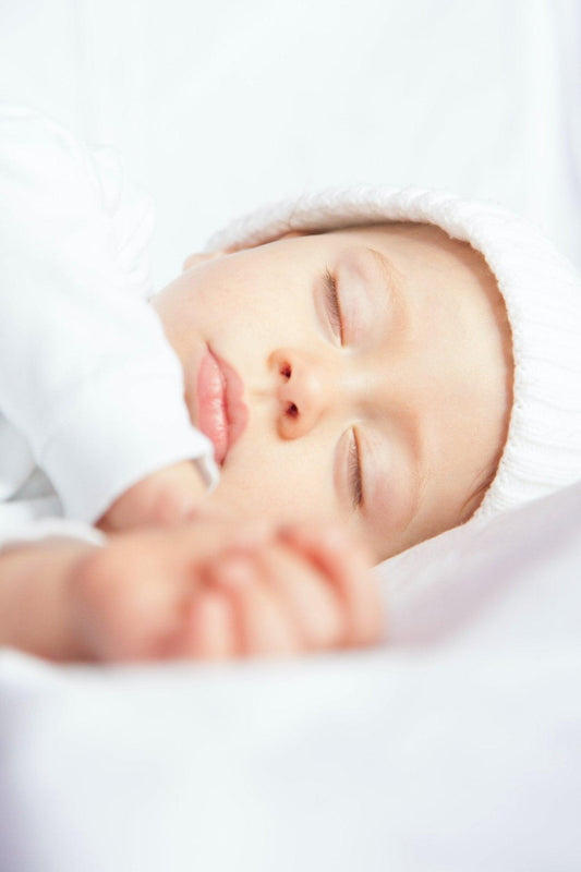 bébé endormi paisiblement, bonnet blanc, sieste, ambiance apaisante, sommeil sécurisé