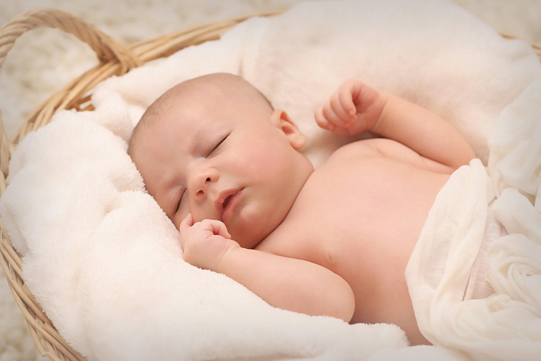 Bébé dormant paisiblement sur une couverture douce dans un panier, ambiance apaisante