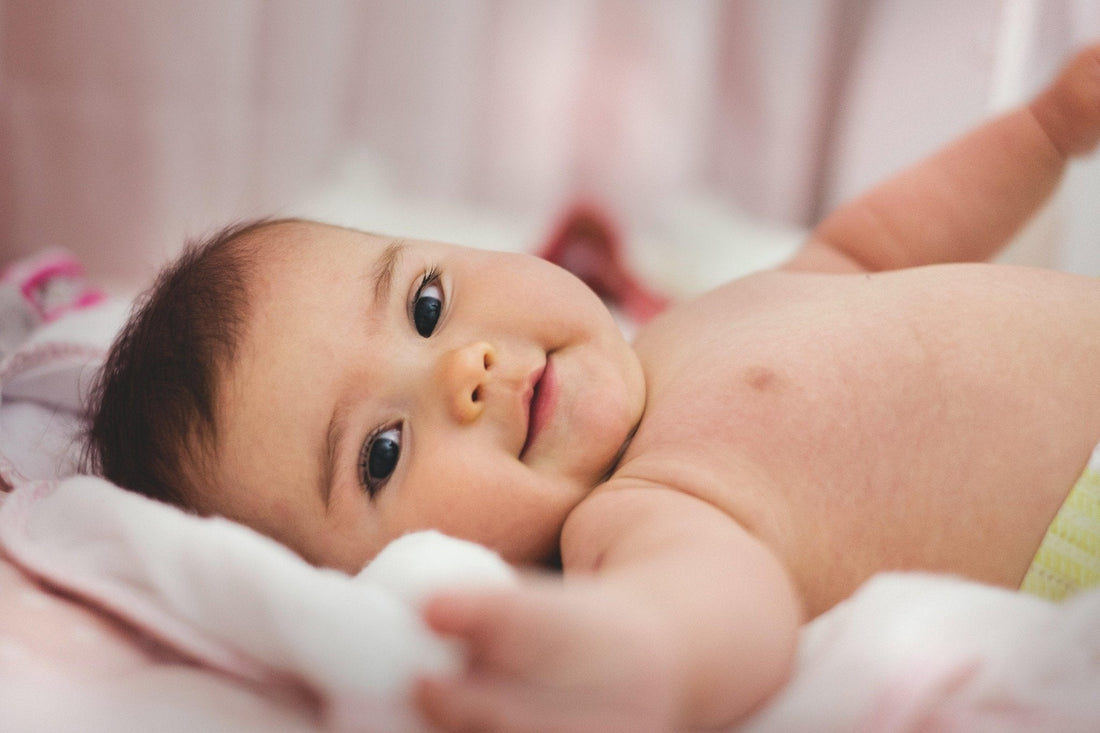Bébé allongé sur un lit, visage serein, ambiance douce et rassurante