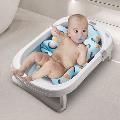 Baignoire bébé  avec bébé couché sur le coussin de bain 