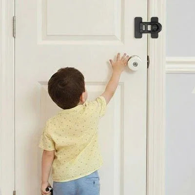 Bloque porte bebe avec enfant en tshirt jaune a coté de la porte 