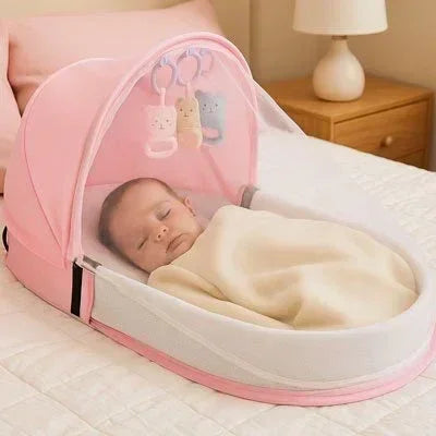 Lit bebe de voyage rose avec bébé qui dort dedans sur le lit