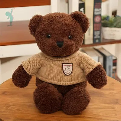 Ours peluche marron avec un pull couleur caramel sur une table