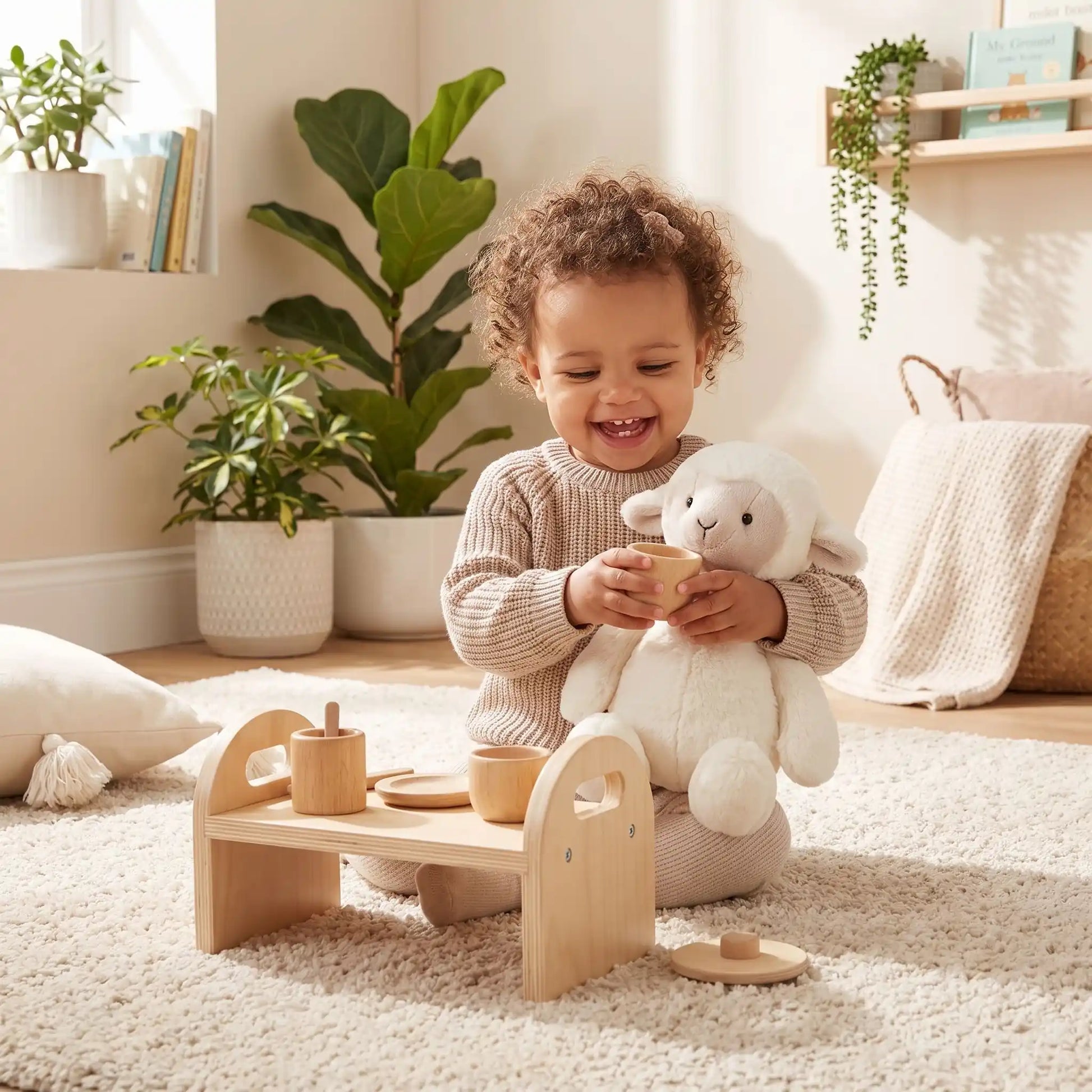 Bébé joue avec doudou mouton et thé en bois, éveil et confort garantis - Nanoukid