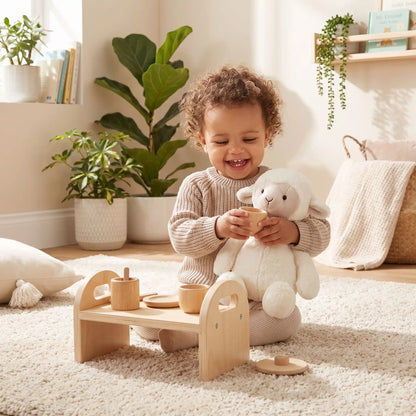 Bébé joue avec doudou mouton et thé en bois, éveil et confort garantis - Nanoukid