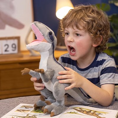 Peluche dinosaure gris qui joue avec un enfant