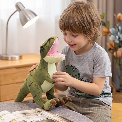 Peluche dinosaure vert avec petit garcon