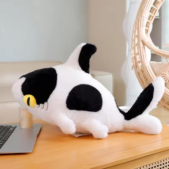 Peluche requin avec des yeux jaune posé sur la commode de bébé