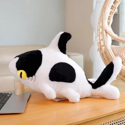Peluche requin avec des yeux jaune posé sur la commode de bébé