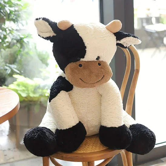 Peluche vache de 50 cm sur une chaise