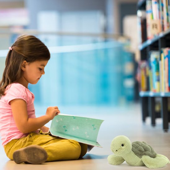Tortue en peluche avec petite fille qui joue