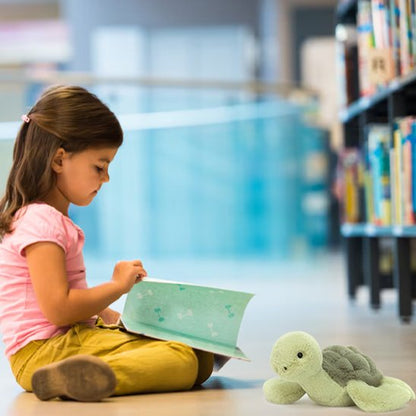 Tortue en peluche avec petite fille qui joue
