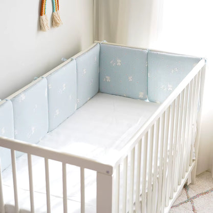 tour de lit epure bleu ciel sur un lit bébé blanc blanc 