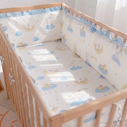 lit bébé en bois avec un tour de lit complet bleu et blanc avec drap assorti