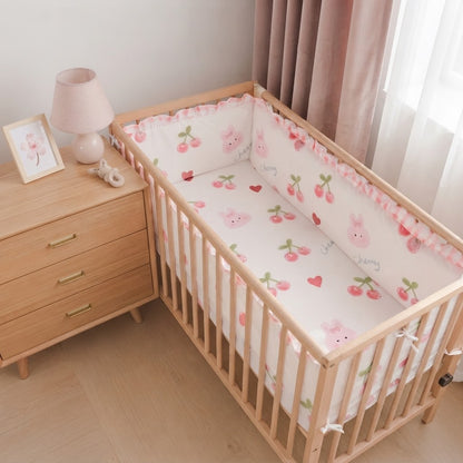 chambre avec commode et lit bébé avec pare choc rose 