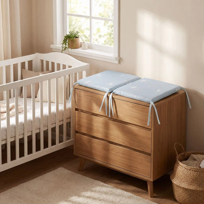  tour de lit modulable posé a coté du lit de bébé sur sa commode