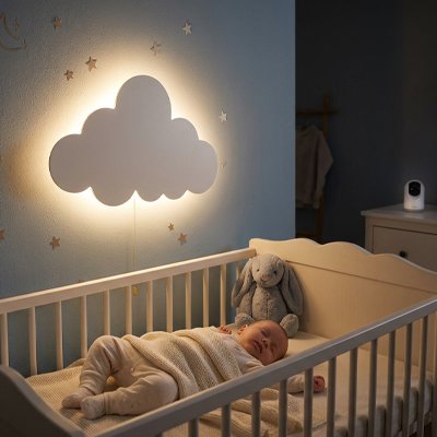 Veilleuse murale nuage allumée au dessus du lit de bébé 